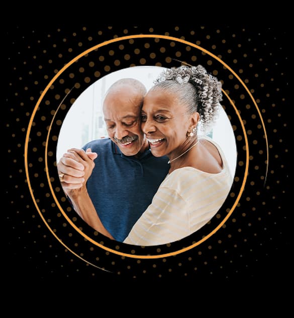 Pareja de ancianos bailando y sonriendo juntos en un cariñoso abrazo.